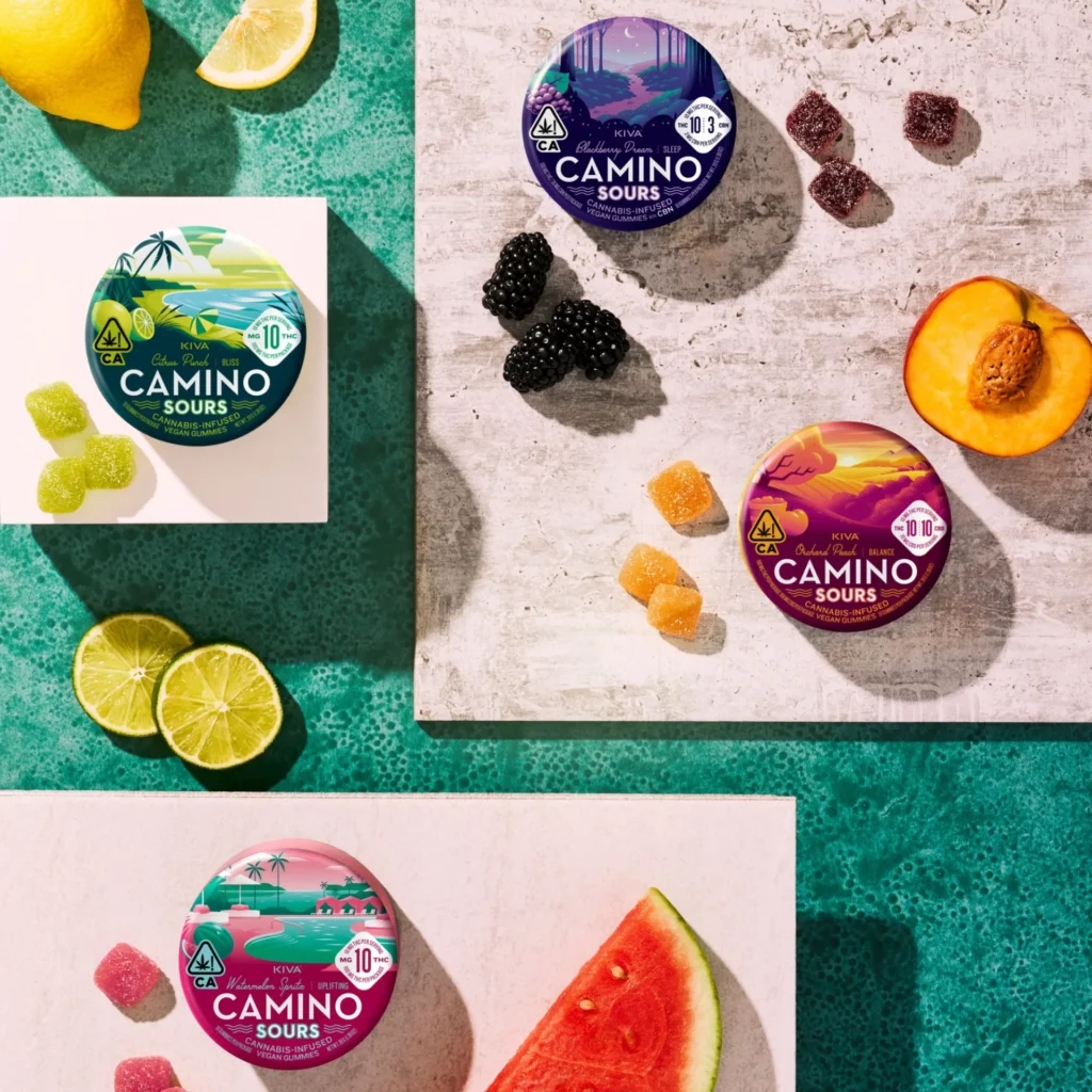 Colorful Camino Sours gummy edibles in packaging, featuring assorted fruit flavors like lime, watermelon, and blackberry, set on a textured surface, highlighting the cannabis-infused treat available at Quality Control Dispensary.